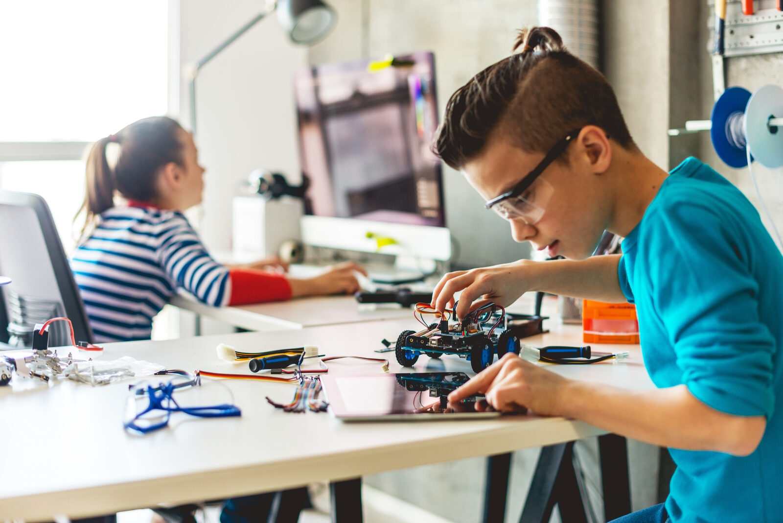 Jugendliche bauen und programmieren in einer Werkstatt