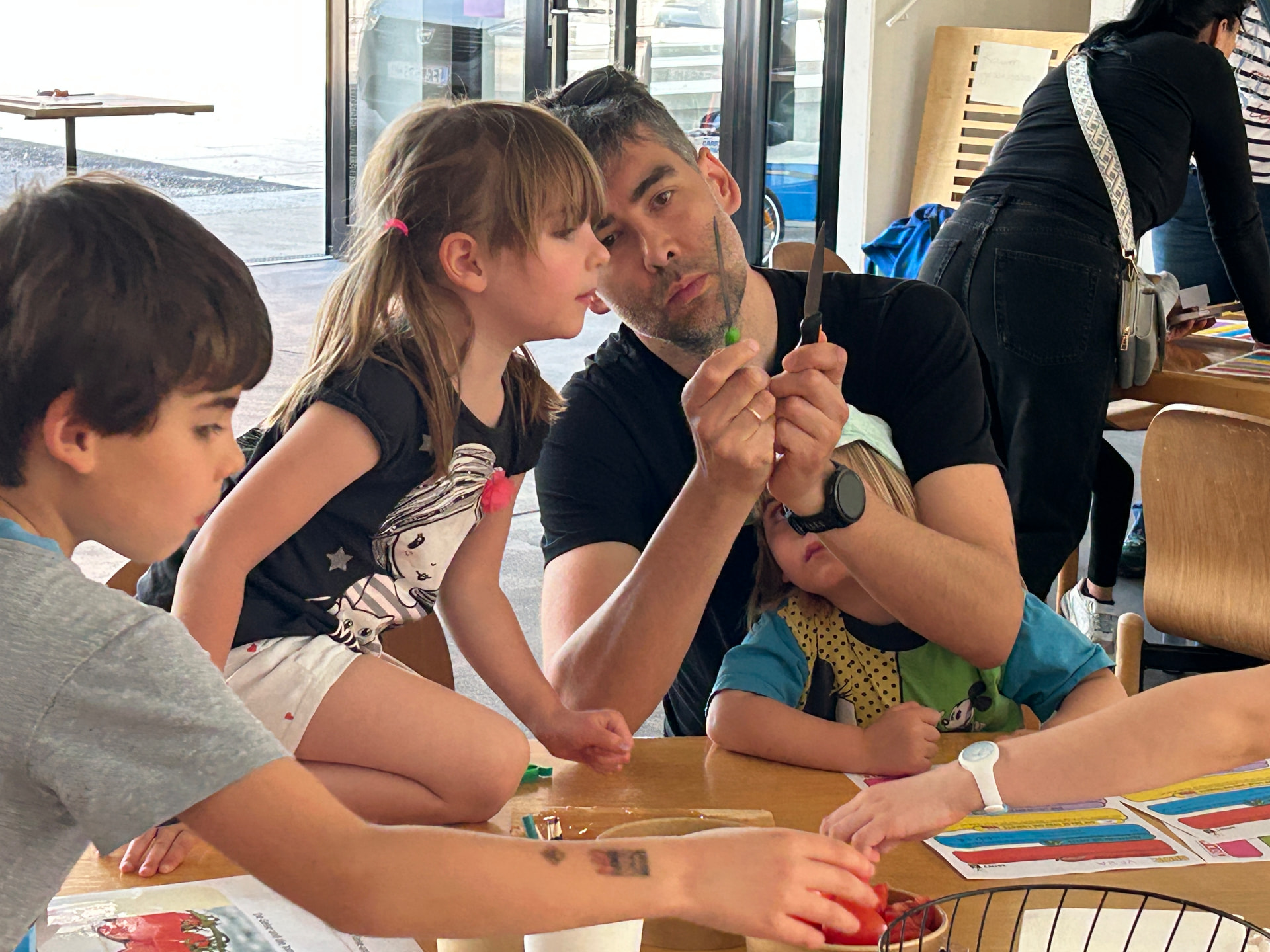 Betreuer zeigt Kindern ein Experiment