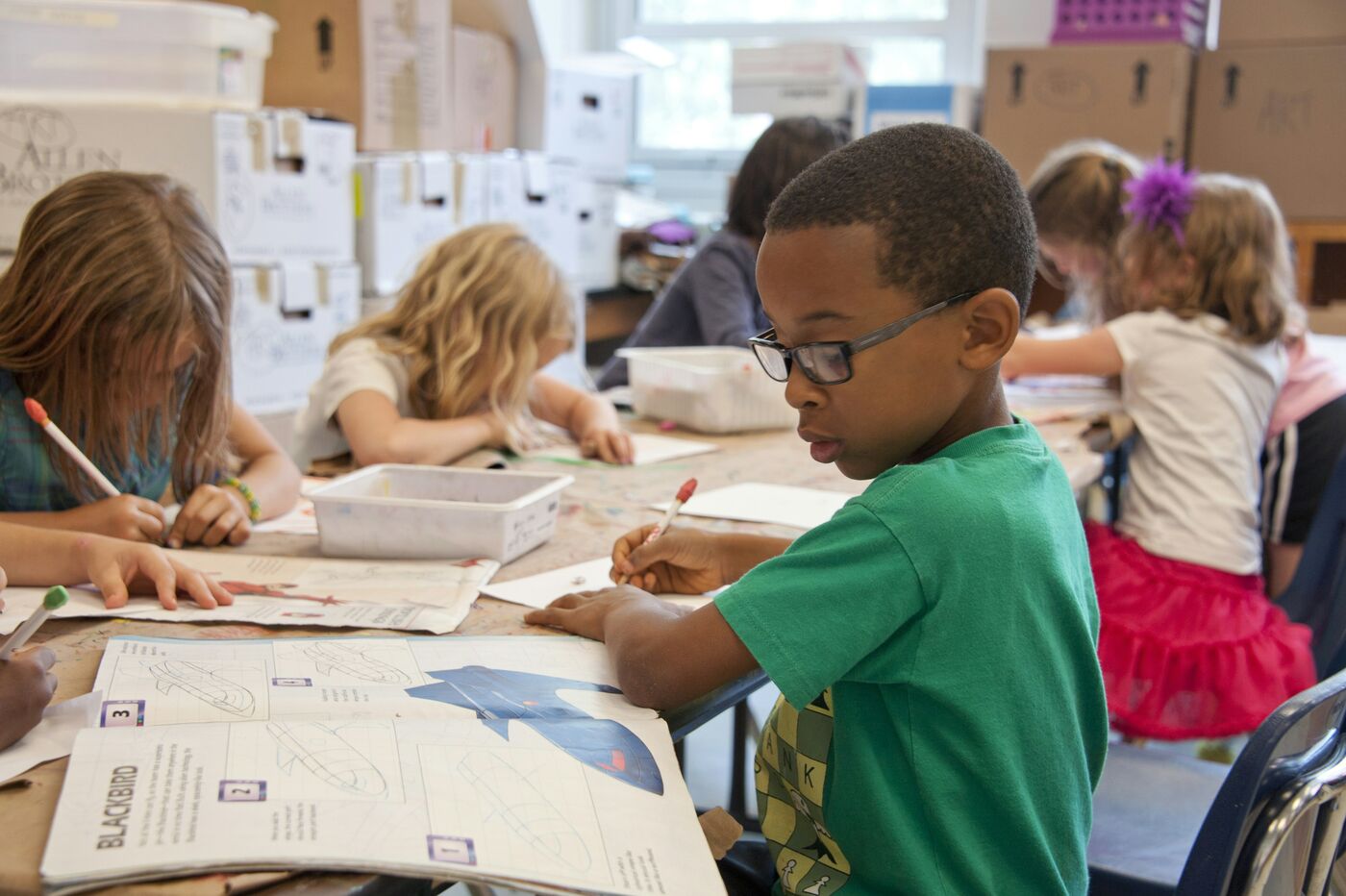 Kinder arbeiten konzentriert an ihren Tischen im Klassenzimmer