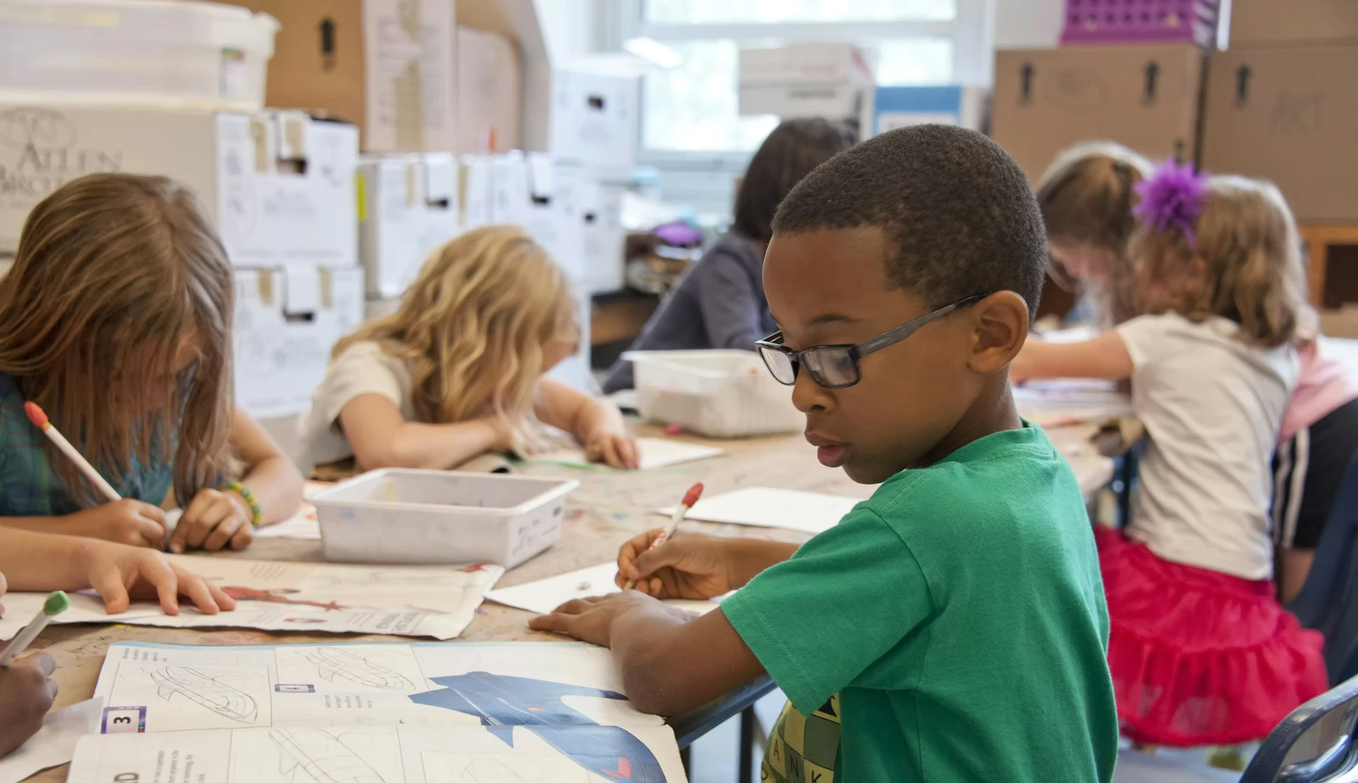 Kinder zeichnen und schreiben im Klassenzimmer