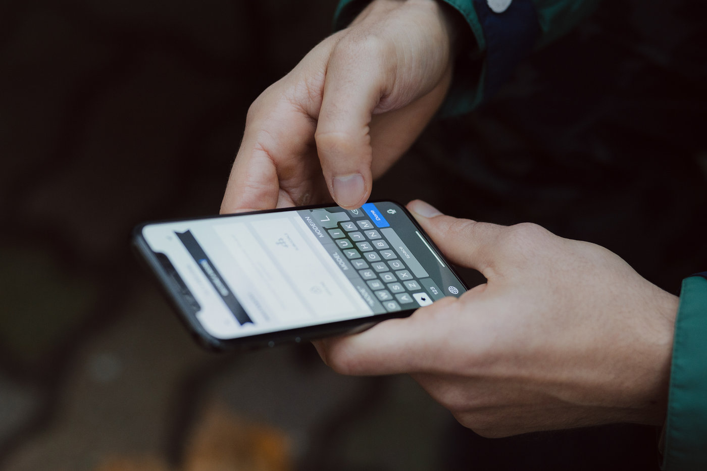 Hände tippen eine Nachricht auf einem Smartphone