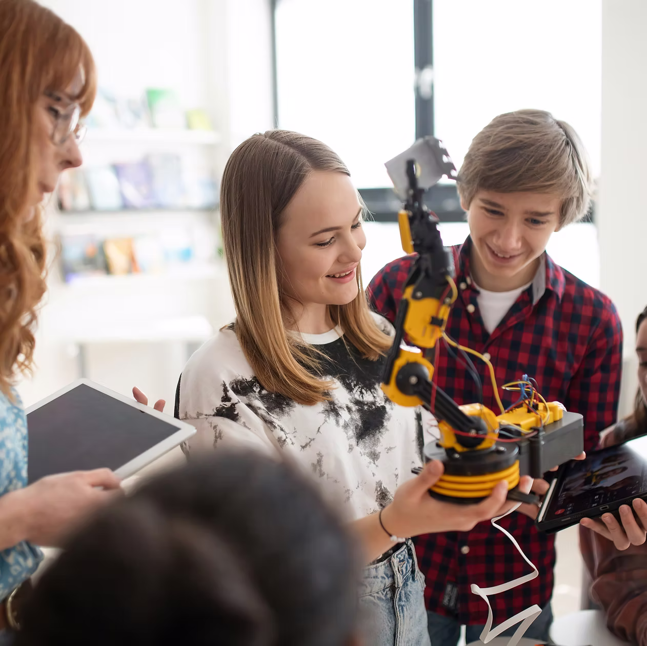 Jugendliche arbeiten an einem Roboterarm