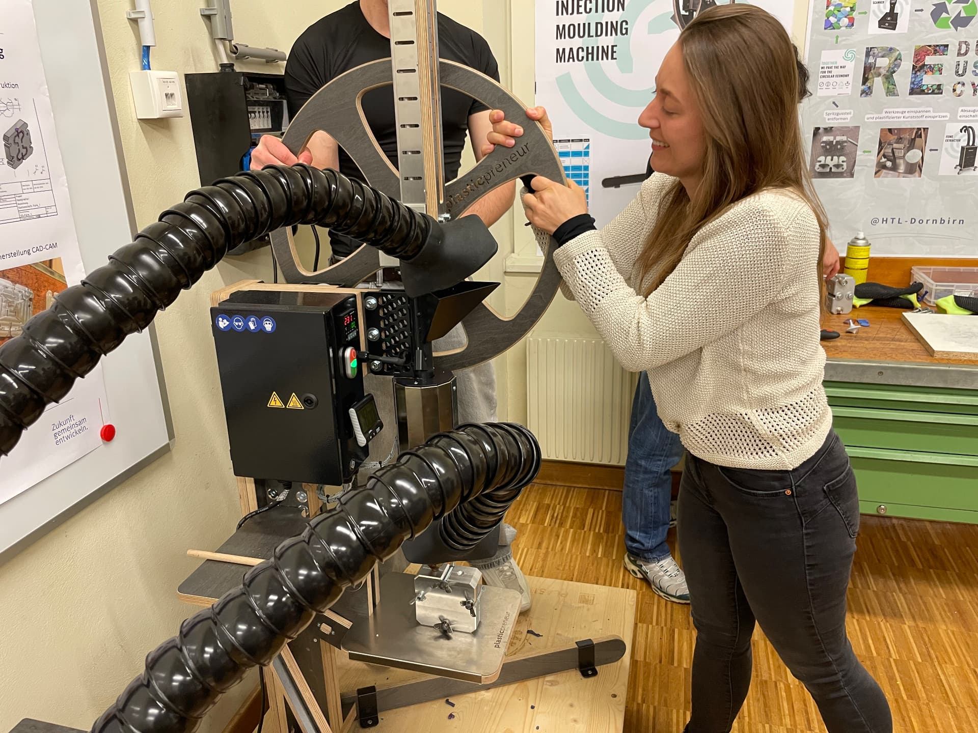 Workshop-Teilnehmerin an einer Spritzgussmaschine