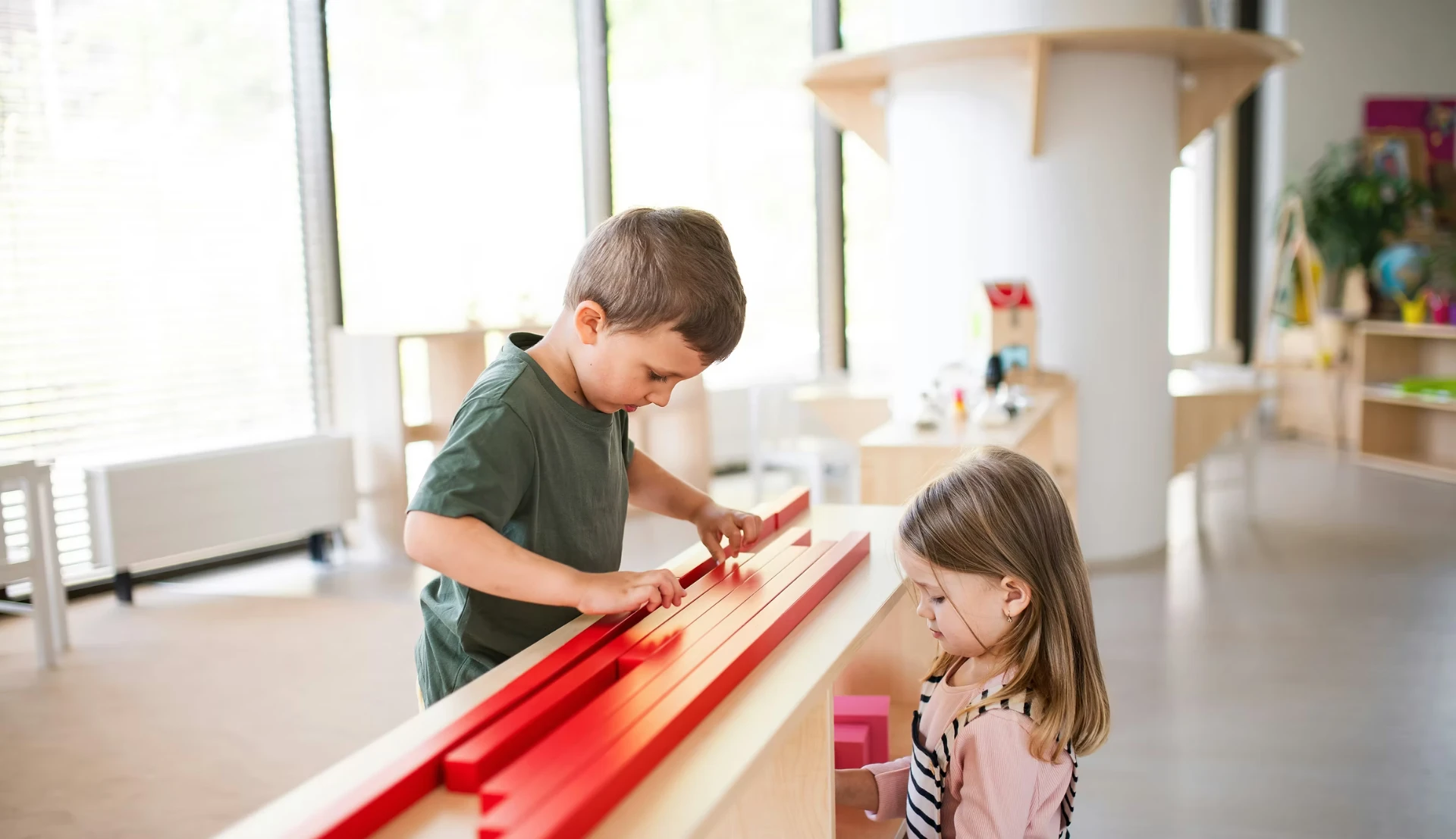 Zwei Kinder spielen mit Holzstäben